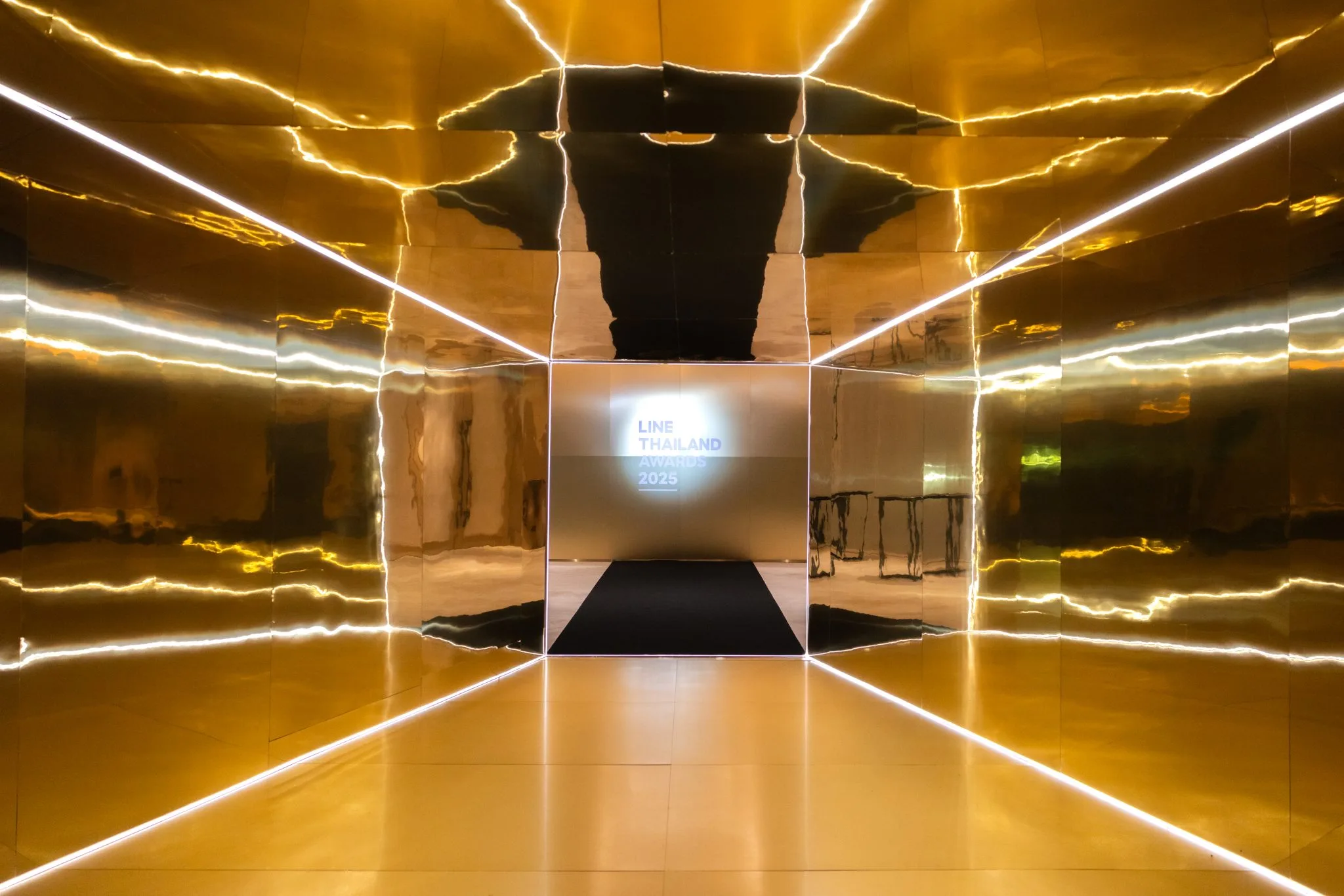 Mirrored gold arrival corridor at the ceremony venue.
